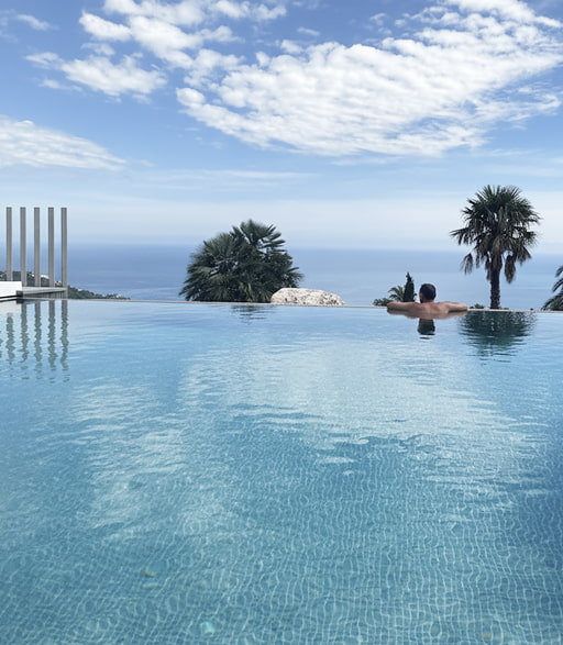 Infinity pool Boy swimming in the infinity pool with sea views